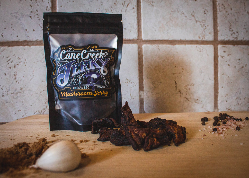 Cane Creek Korean BBQ mushroom jerky bag with jerky pieces on a table