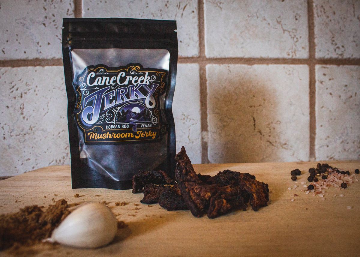 Cane Creek Korean BBQ mushroom jerky bag with jerky pieces on a table